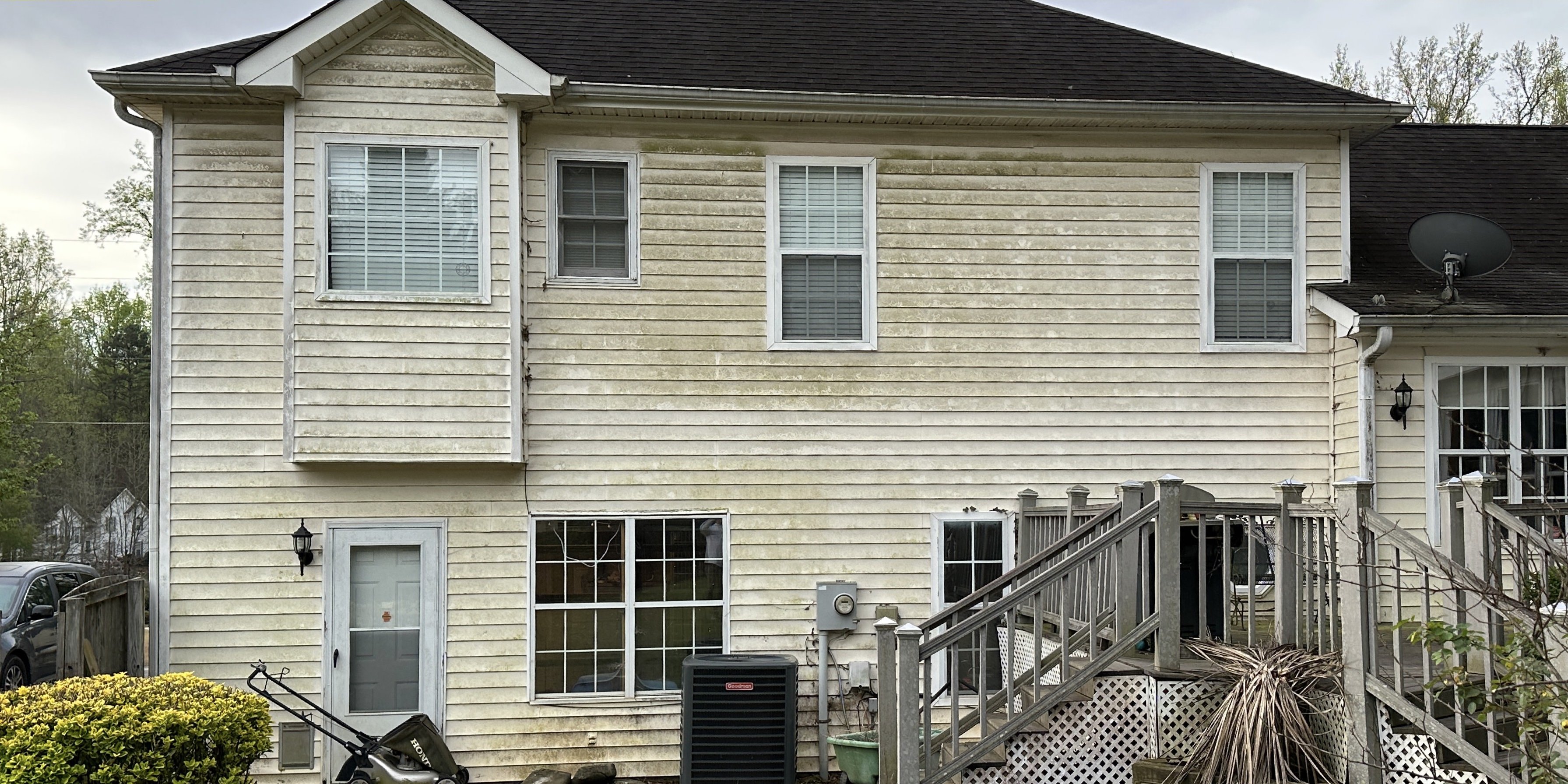 House siding covered in green algae and mildew before washing