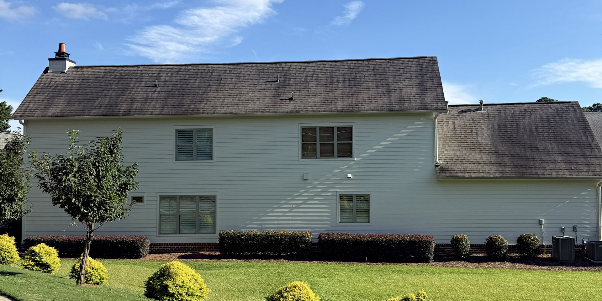 Roof shingles with black algae streaks before cleaning
